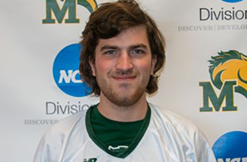 Young man smiling in a jersey in front of a marywood backdrop.